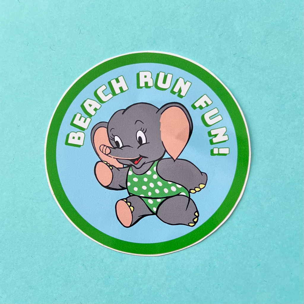 Grey elephant in a green polka dot bikini running along a beach having fun. Pale blue sky background. Words on it say beach fun run. Cute elephant has a little smile. A round sticker with white text and a bright green drop shadow and a thick bright green line around the edge of the circle. Water resistant, glossy sticker approximately 88mm in diameter.